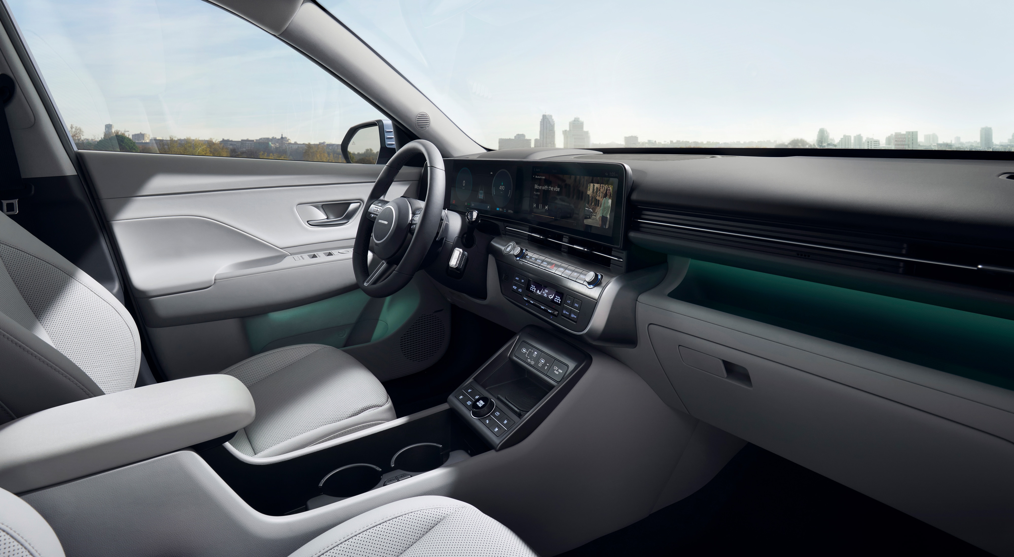 The inside view of the Hyundai KONA with green ambient lighting highlighting the display and the doors.