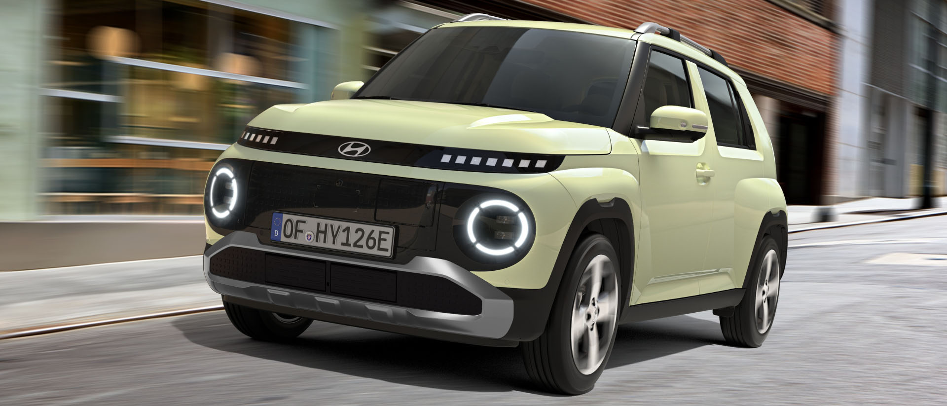 The Hyundai Inster speeding up in front of a building.