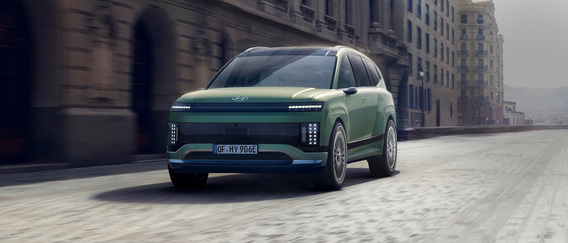 Three-quarter view of the new Hyundai IONIQ 9 driving in the city.