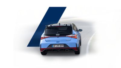 The all-new Hyundai i20 N, seen from the rear, driving a race track.