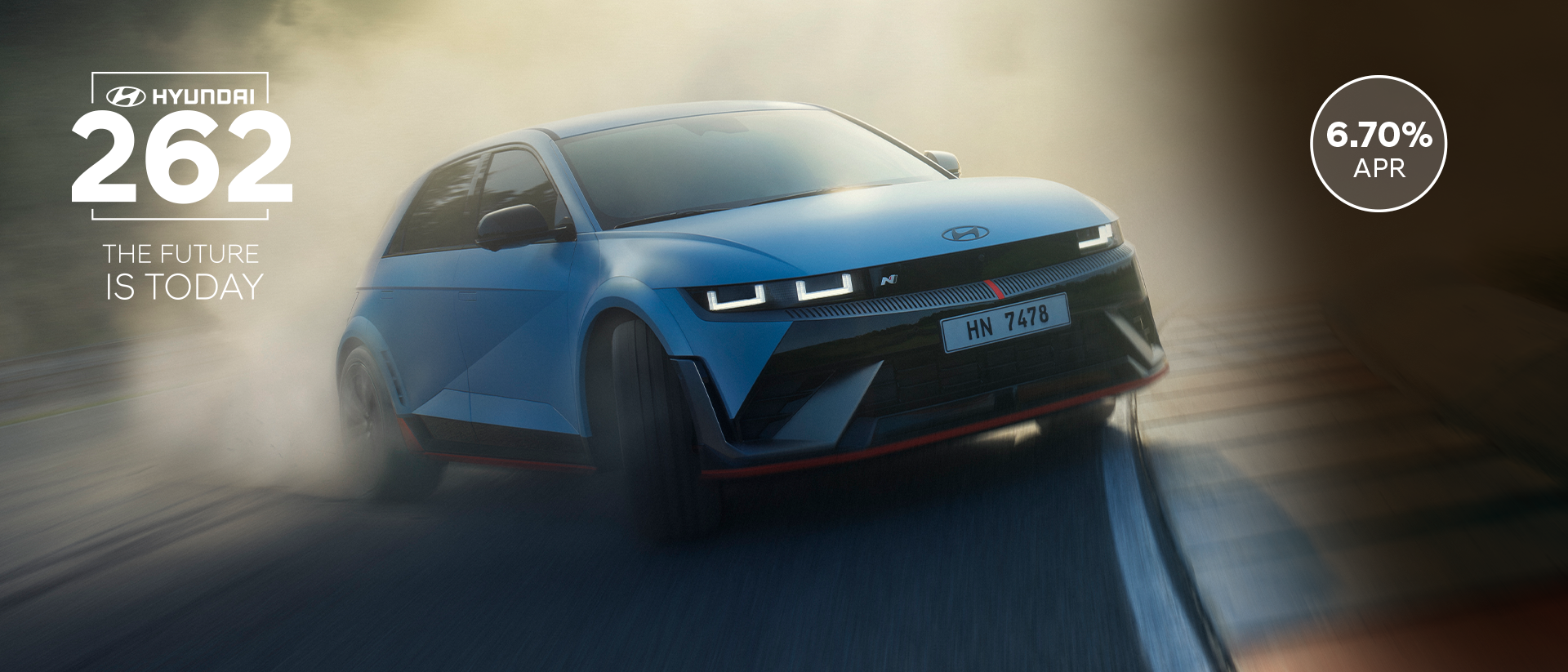The all-electric Hyundai IONIQ 5 N drifting through a curve on a racetrack with smoking tyres.