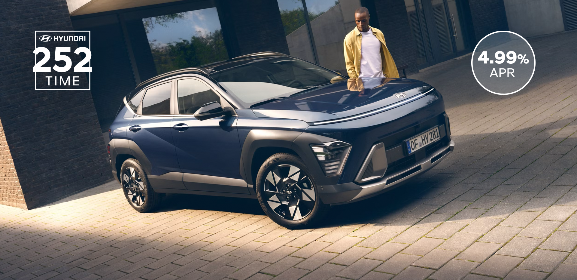 The all-new Hyundai KONA in blue parked next to a men with yellow shirt.