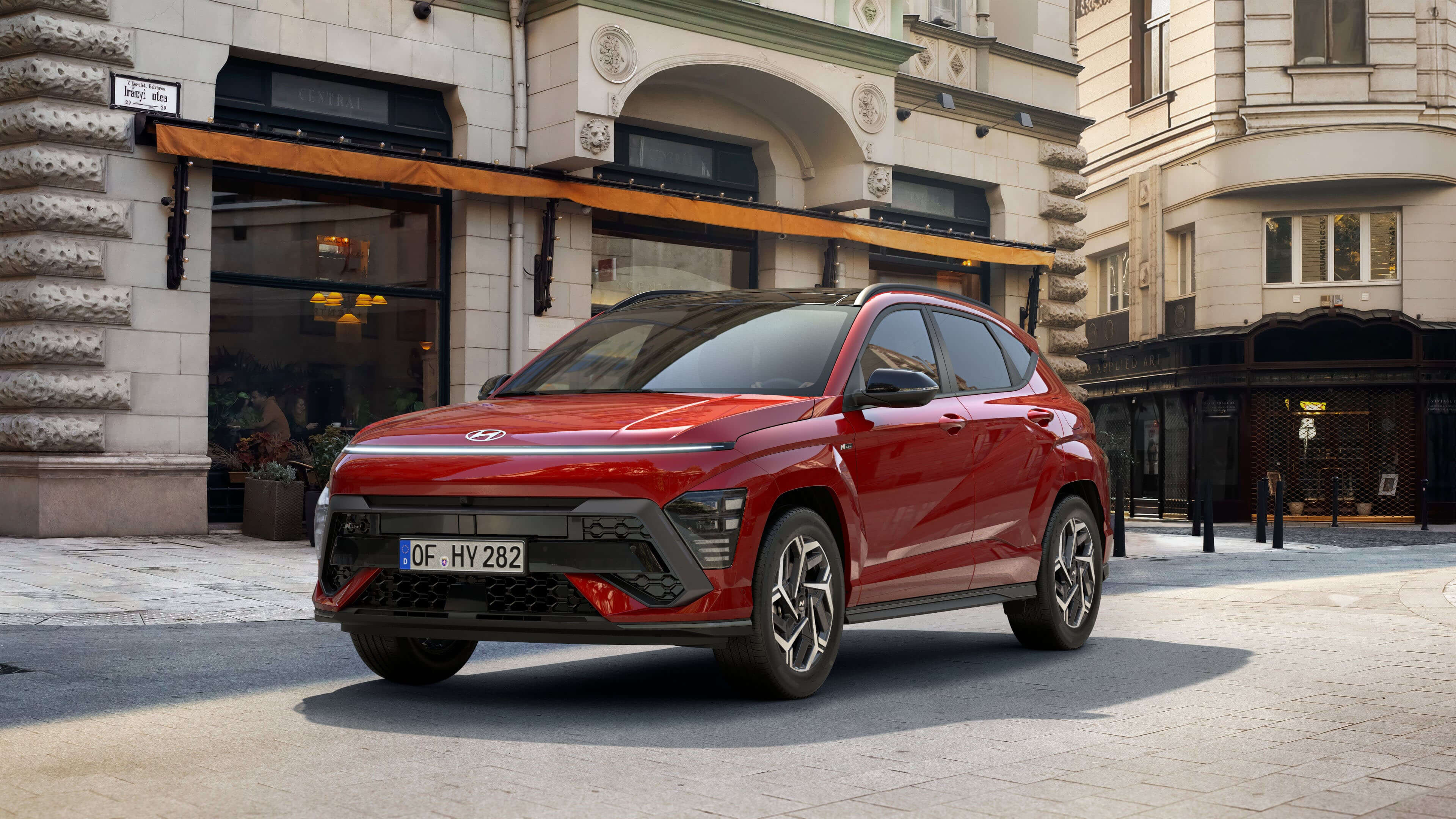 The all-new Hyundai KONA N Line in red parked in front of an architecture building.&nbsp;