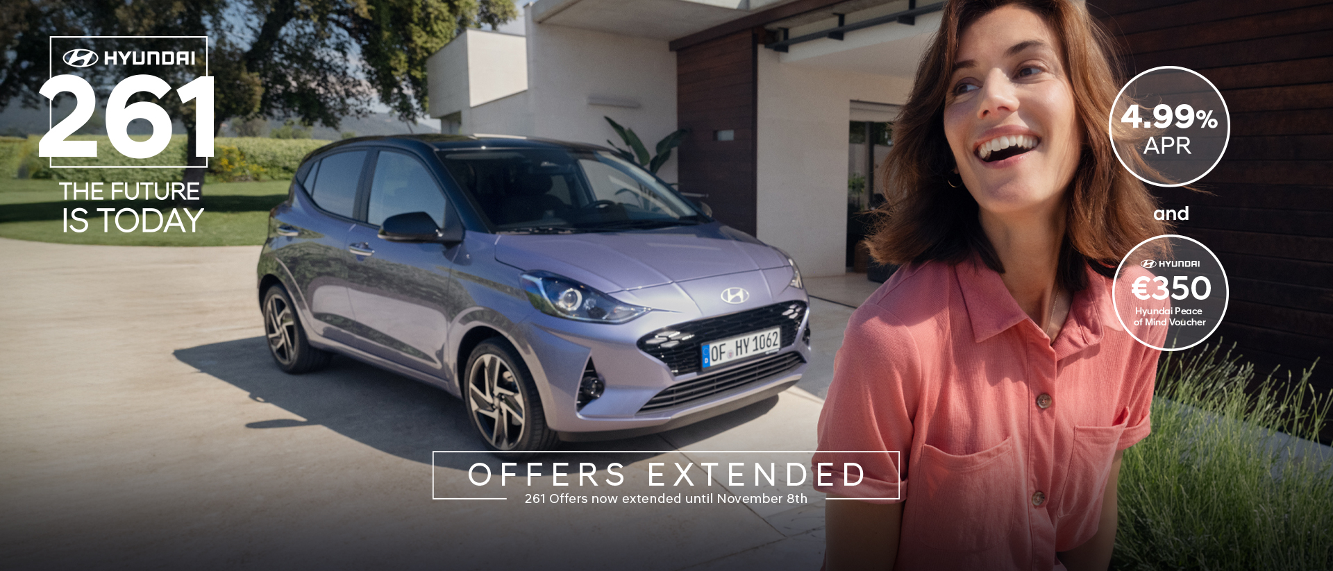 A woman walking and smiling in front of the new Hyundai i10.