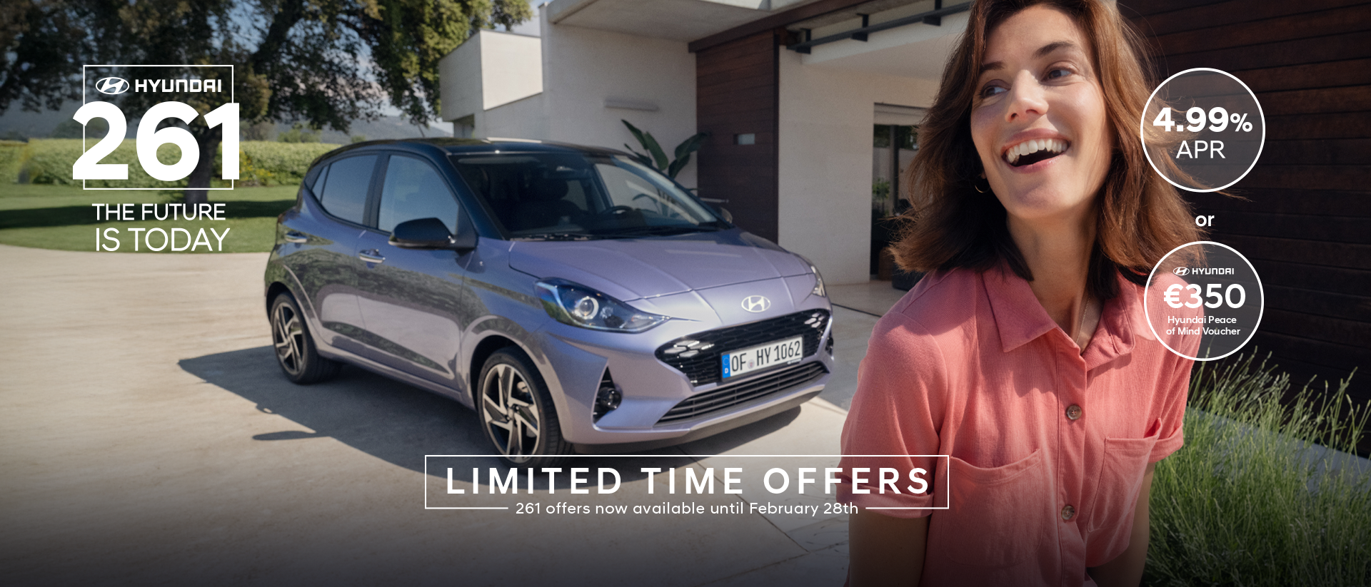 A woman walking and smiling in front of the new Hyundai i10.