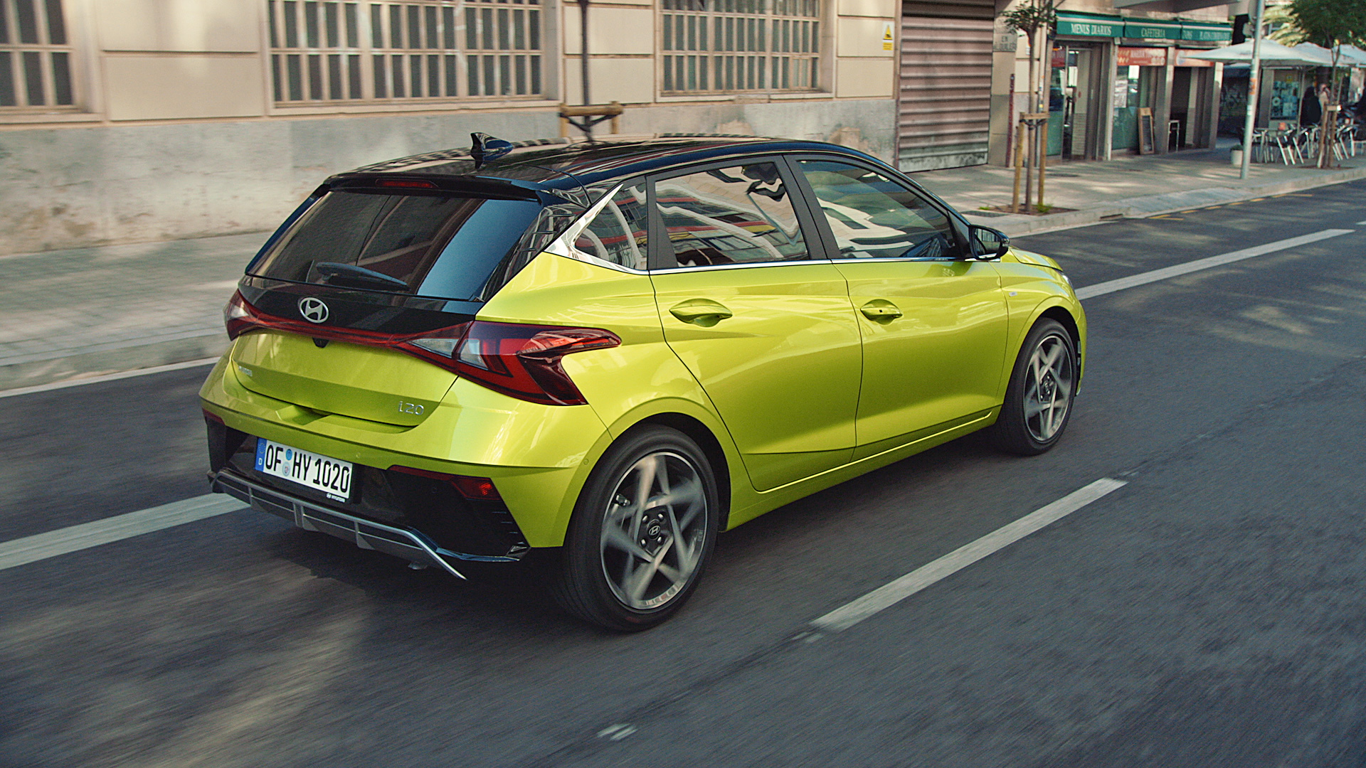 The Hyundai i20 in Lucid Lime Metallic driving through the streets.
