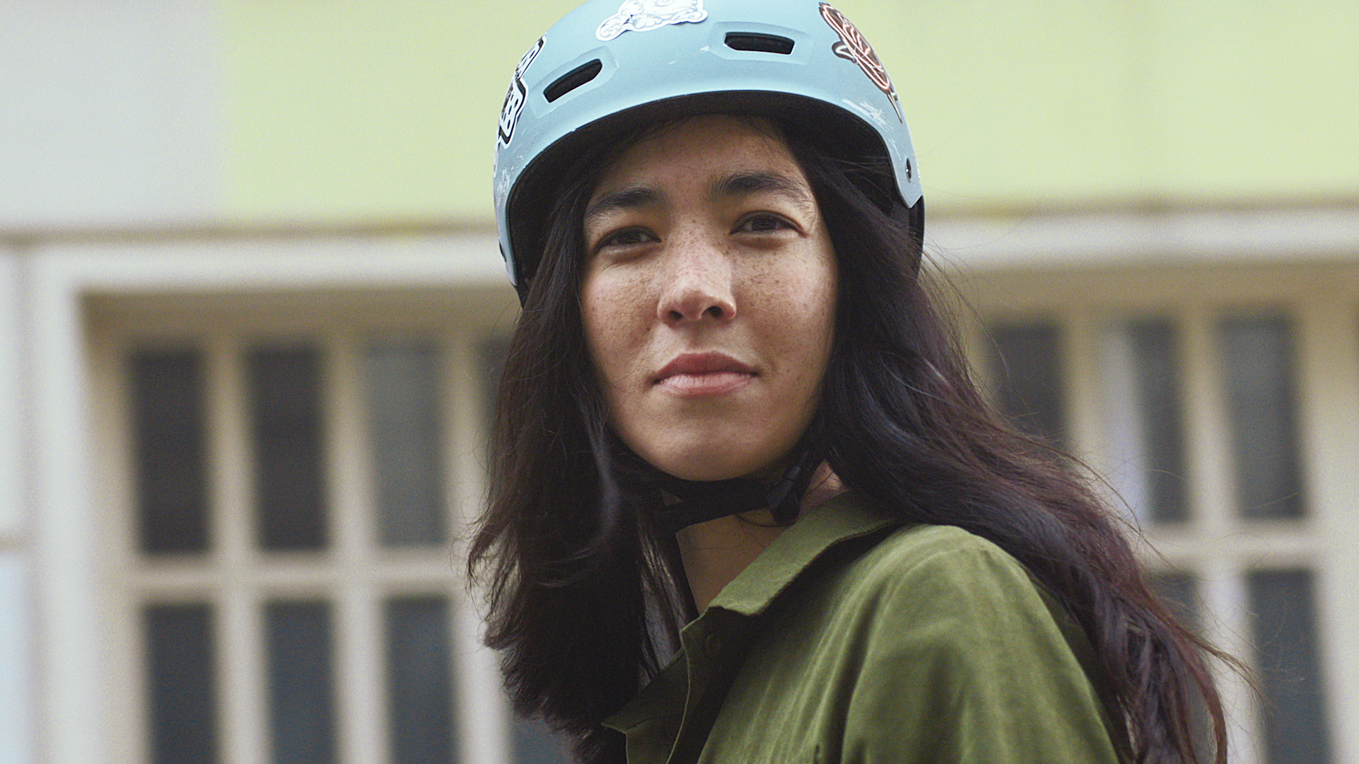 A woman wearing a helmet gazes at the camera.