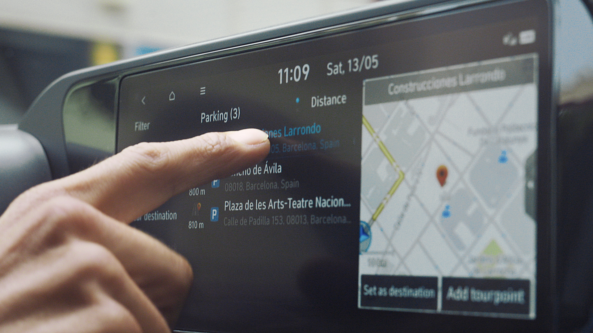 A man's finger using the touchscreen panel of the Hyundai i20.