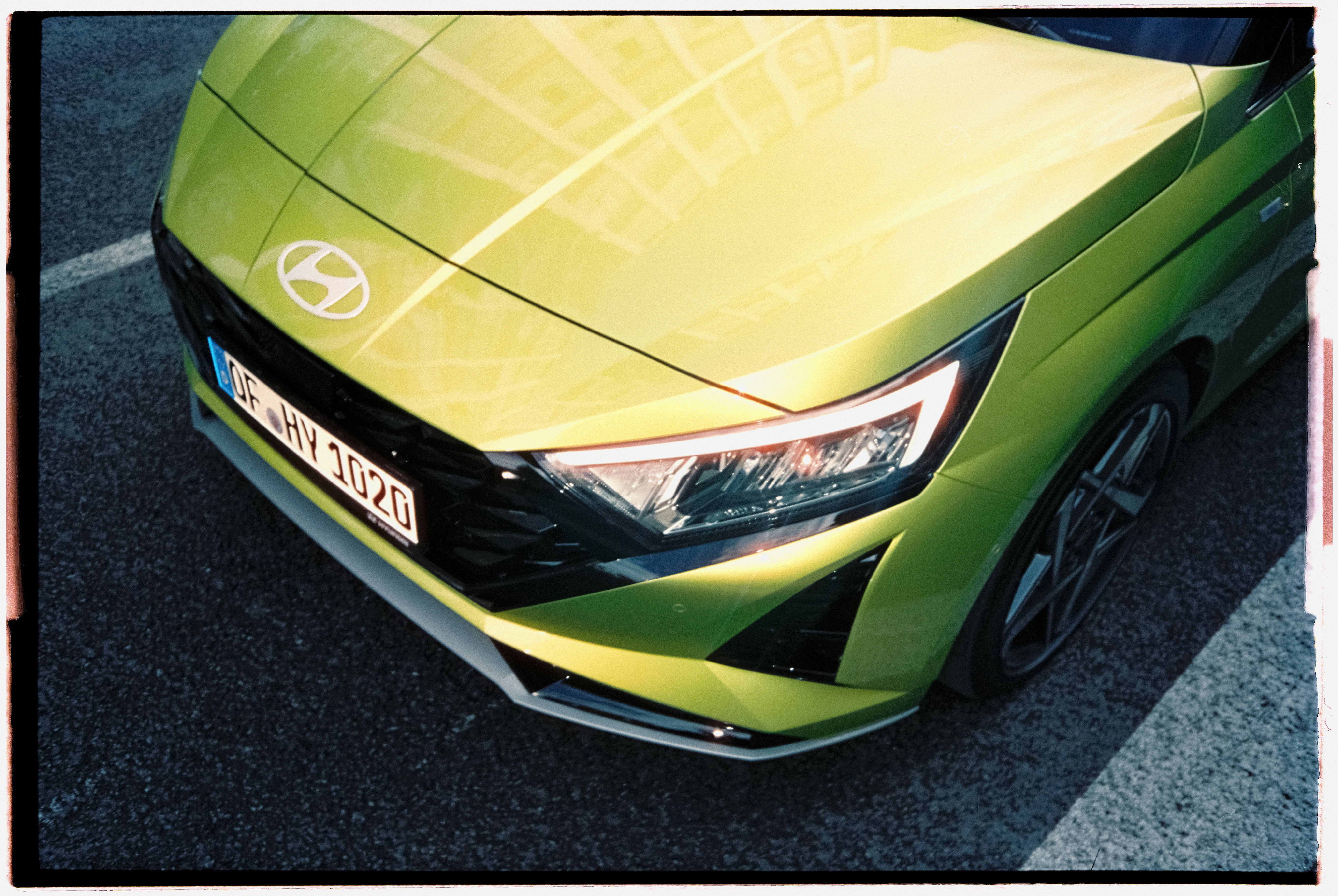 The front of a green Hyundai i20, seen from above, with a clear view of the left headlamp.