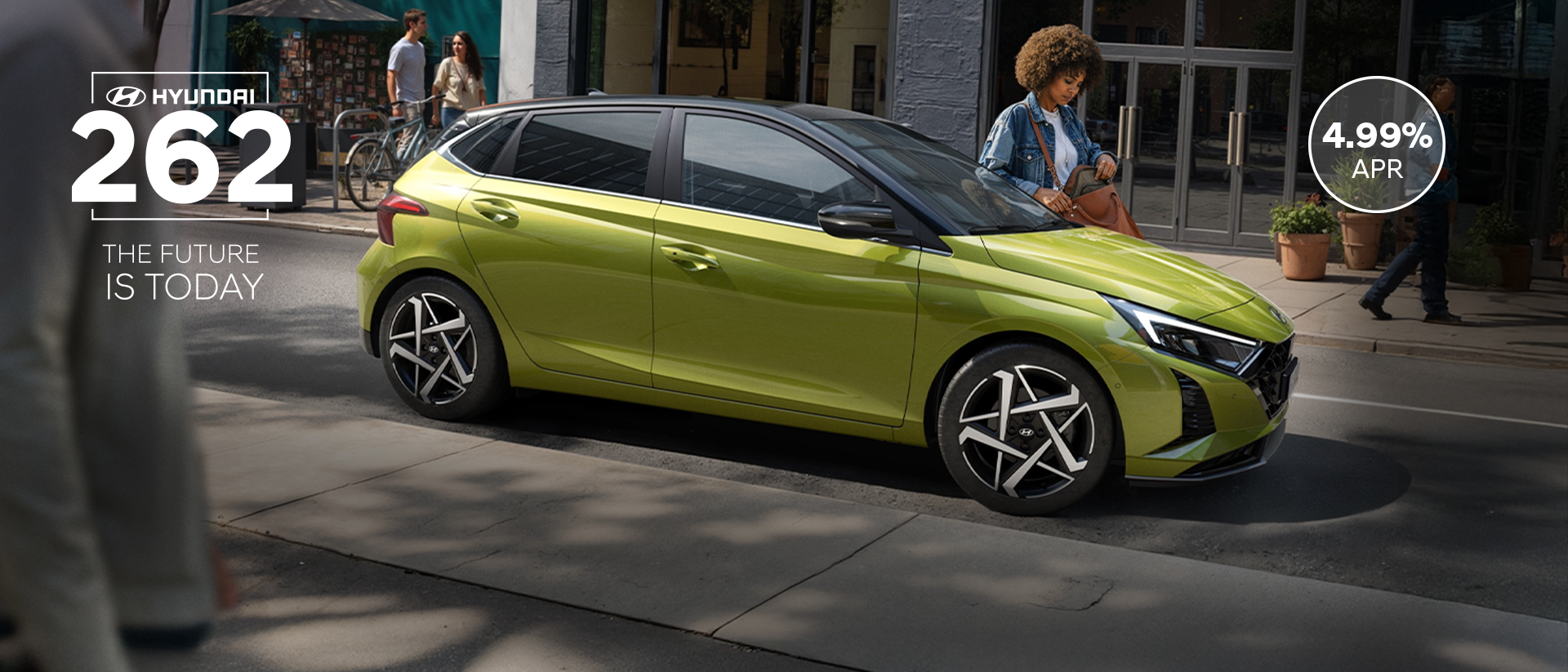 A young woman skateboarding in the street with a Hyundai i20 in the background.	
