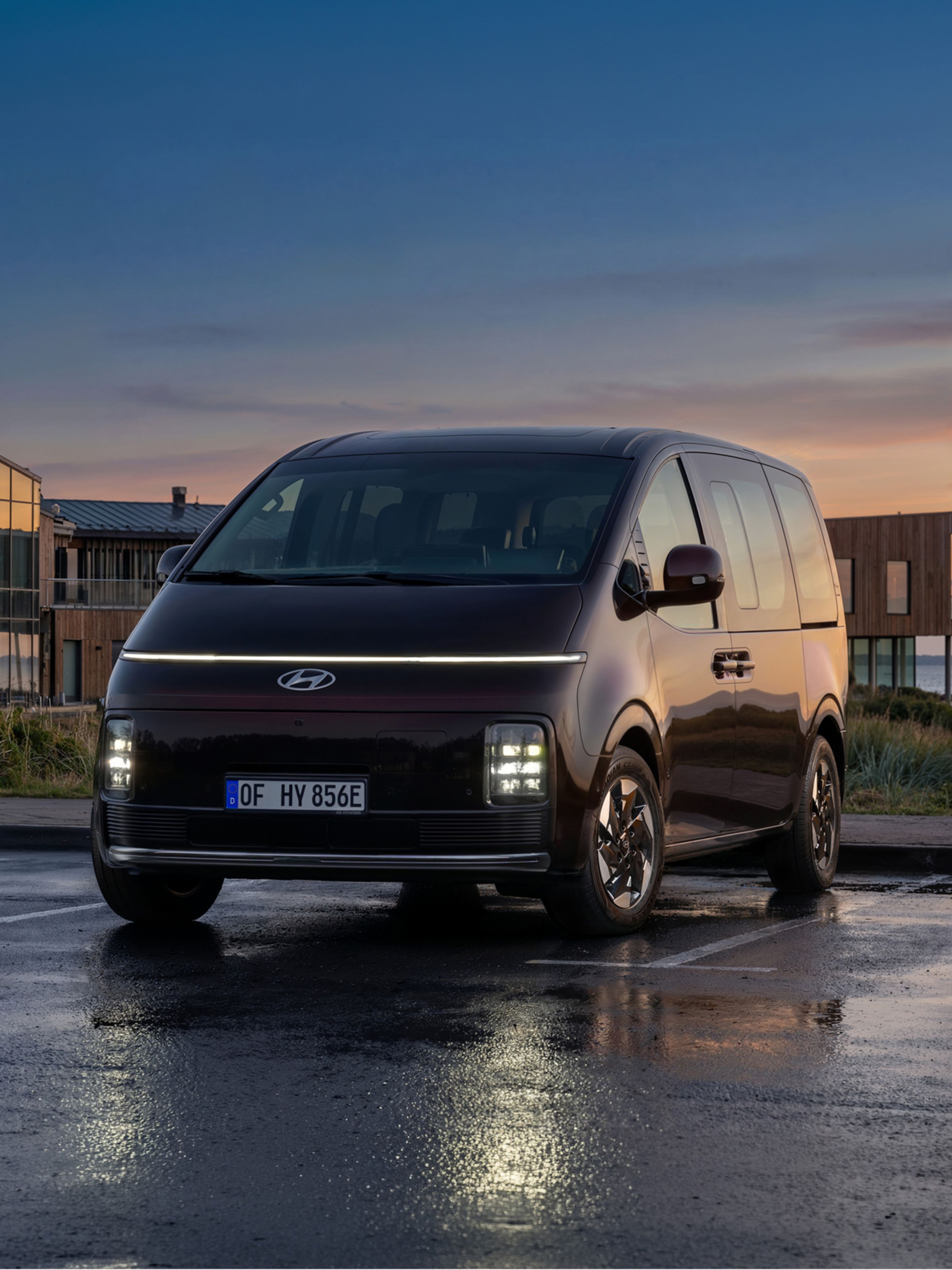 Hyundai STARIA Electric viewed from the front, with a sunset in the background.