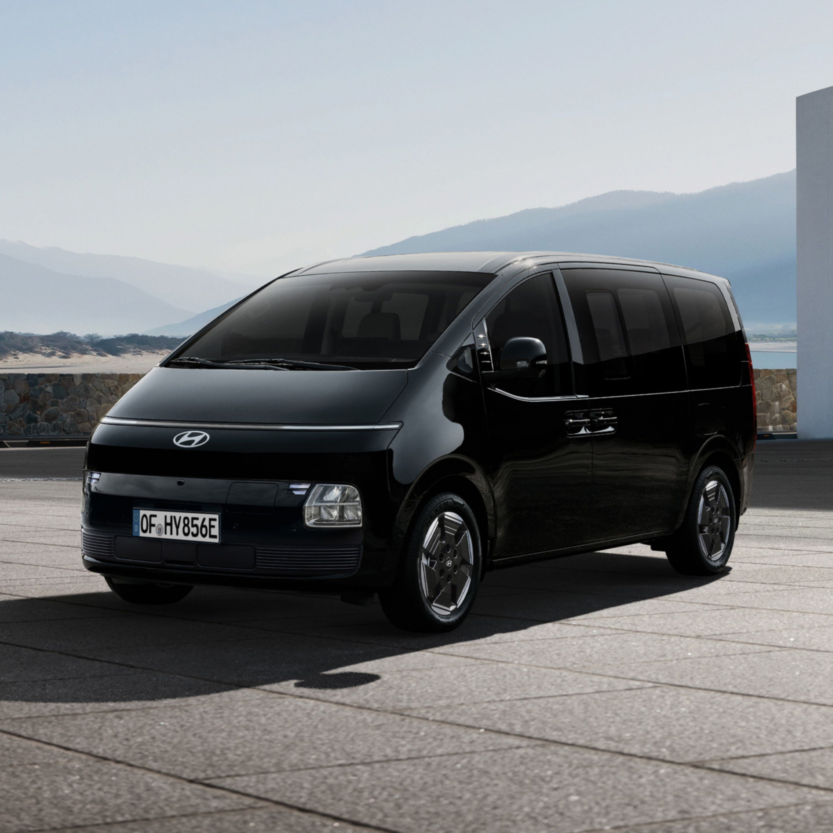 Hyundai STARIA Electric parked outdoors with mountain landscape in the background, viewed from the front three-quarter angle.