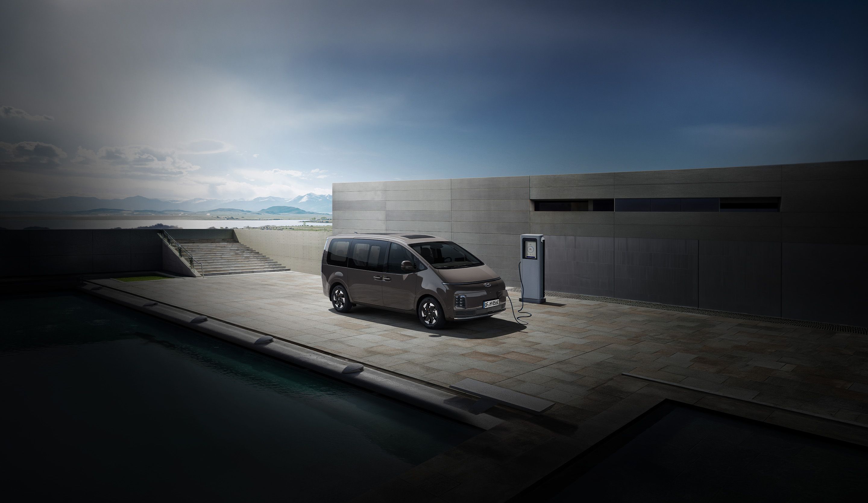 Hyundai STARIA Electric connected to an EV charger outdoors, highlighting convenient charging access.