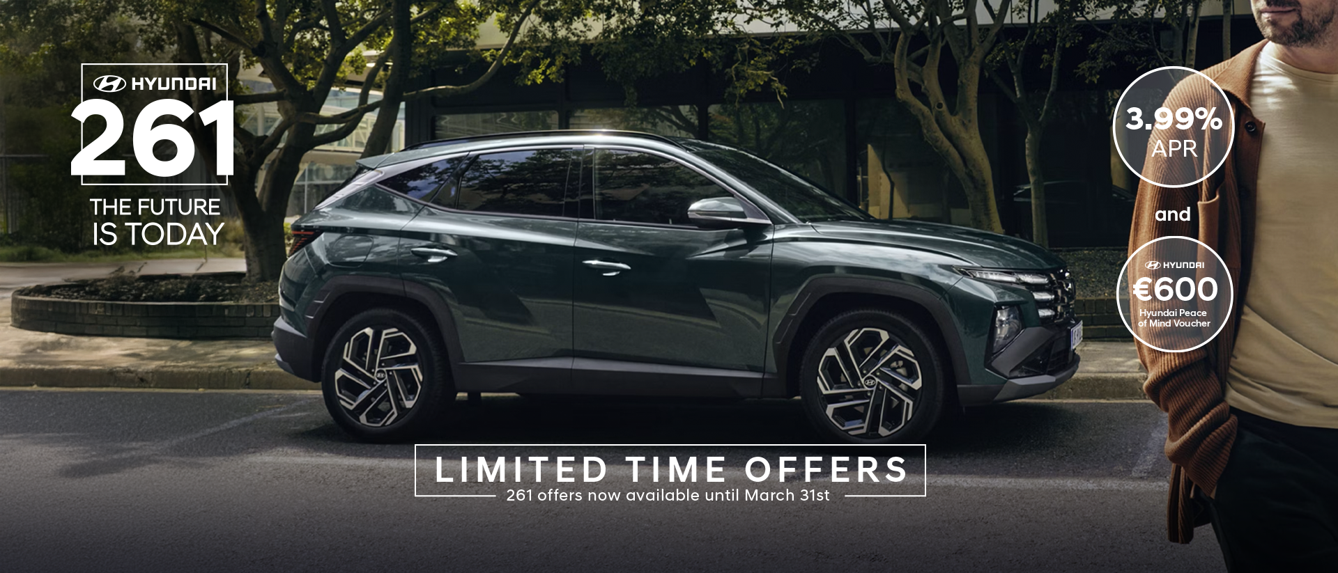 A man walking near a Hyundai&nbsp;TUCSON Hybrid parked by some trees.